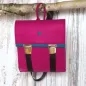 Preview: Kleiner pinker Rucksack aus Filz mit türkisfarbenem Innenleben und verstellbaren Trägern im Detail.