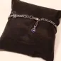 Preview: Versilbertes Gliederarmband mit blauem Auge-Anhänger präsentiert auf einem edlen schwarzen Schmuckkissen.