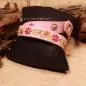 Preview: Nahaufnahme der farbenfrohen Blumen-Stickerei auf dem rosa Wickelarmband.