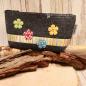 Preview: Handgenähte Kosmetiktasche aus dunkelgrauem Filz mit bunten Blumen und gestreiftem Band.