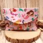 Preview: Großer handgenähter Geldbeutel von chic-peppig-bunt aus rosa Stoff mit Meerjungfrauen und pink gepunktetem Innenfutter auf hellem Hintergrund.
