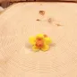 Preview: Handgefertigter gelber Filzring für Kinder in Blumenform mit orangefarbenen Akzenten auf verstellbarer Ringschiene.