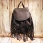 Preview: Schwarzer Leder-Rucksack mit langen Fransen, Magnetknopf-Verschluss und Kordelzug, Rückansicht mit verstellbaren Schultergurten.