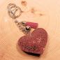 Preview: Glitzernder Schlüsselanhänger mit Stoff-Herz, silberner Gliederkette, Quaste und Karabinerhaken.