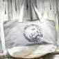 Preview: Graue Shoppertasche mit silbernem Yin Yang Pailletten-Motiv, weißem Boden mit Silberstreifen und grauen Kunstleder-Griffen vor Holz-Hintergrund.