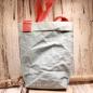 Preview: Nachhaltige hellblaue Shoppertasche aus waschbarem Papier mit auffälligem orangem Schulterband, handgefertigt von Maxx Factory.