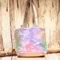 Preview: Kleine lila-blau schimmernde Kindertasche mit Pailletten-Stickerei, silbernem Boden und grauen Kunstleder-Griffen auf rustikalem Holzgrund.