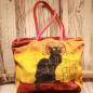 Preview: Stoff-Shoppertasche Chat Noir in Rot-Gelb mit schwarzer Katze, Vintage-Look durch Sonneneinstrahlung, Ansicht von vorne und rotes Innenfutter.