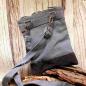 Preview: Rückseite der Stoff-Handtasche mit Fokus auf die silbernen Karabinerhaken des abnehmbaren Schulterbands.
