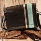 Preview: Rückseite der Filztasche mit Fokus auf die senkrecht verlaufenden Zierbordüren und das seitliche Stoff-Label.