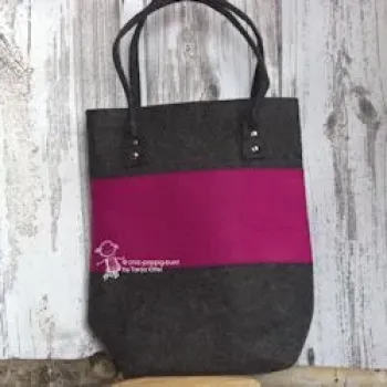 Große pinke Shoppertasche aus Filz mit stabilen Metallnieten an den Henkeln, handgefertigt, vor weißem Hintergrund.
