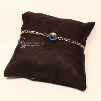 Filigranes, versilbertes Metall-Armband mit mittig platziertem Evil Eye (blaues Nazar-Auge) vor hellem Hintergrund.