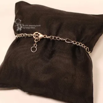 Rückansicht des versilberten Metall-Armbands auf schwarzem Kissen mit Fokus auf den Karabiner-Verschluss.