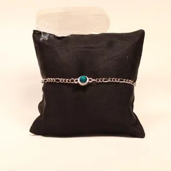 Frontalansicht des versilberten Metall-Armbands auf dunklem Schmuckkissen mit Fokus auf den gefassten Stein.