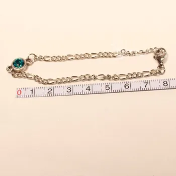Versilbertes Bettelarmband an einem Maßband zur Veranschaulichung der Gesamtlänge von 19 cm.