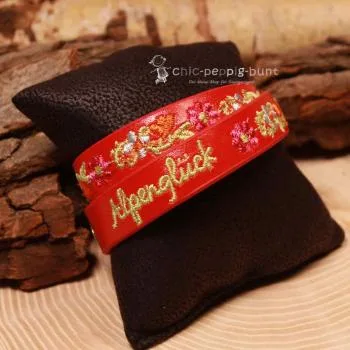 Nahaufnahme der hochwertigen Blumen-Stickerei auf dem roten Wickelarmband für Kinder.