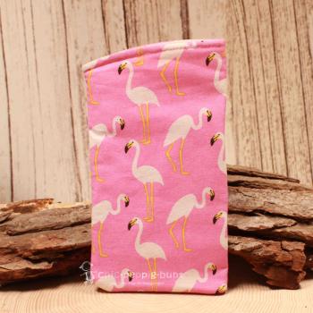 Handgenähtes rosa Brillenetui von chic-peppig-bunt mit weißen Flamingos und rosa-pink gepunktetem Innenstoff auf hellem Hintergrund.