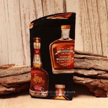 Handgenähtes schwarzes Brillenetui von chic-peppig-bunt mit Whiskey-Flaschen-Motiv und schwarz-weiß gepunktetem Innenstoff auf hellem Hintergrund.