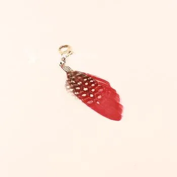 Roter Charmsanhänger Feder mit weißen Polka Dots und silbernem Karabiner-Verschluss.
