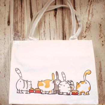 Helle Shoppertasche aus Polyester mit drolligen Katzen-Motiven und roten Futternäpfen.