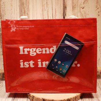 Nahaufnahme des Slogans „Irgendwas ist immer“ auf dem roten Polyester-Gewebe.