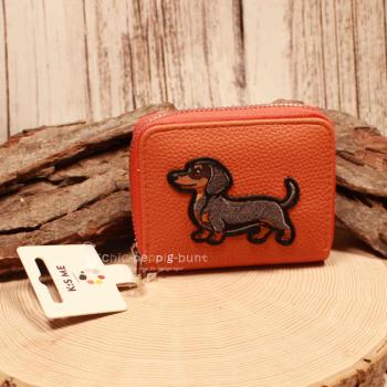 Orangefarbener Kindergeldbeutel mit Dackel Sir Winston, Kunstleder, Reißverschluss offen mit 6 Fächern.