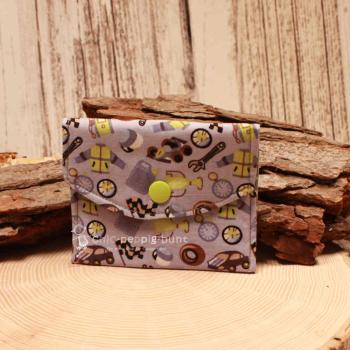 Kleiner handgenähter Geldbeutel von chic-peppig-bunt aus grauem Stoff mit Rennautos und Werkzeug sowie grünem Punkt-Futter auf hellem Hintergrund.