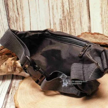 Rückseite der dunkelgrauen Hüfttasche mit Fokus auf das Reißverschlussfach hinten und die robuste Gurtschnalle mit Steckverschluss.