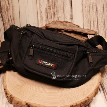 Schräge Ansicht der schwarzen Gürteltasche mit Fokus auf die 4 Reißverschlussfächer an der Vorderseite.