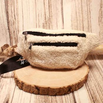 Flauschige weiße Gürteltasche aus weichem Plüsch-Stoff mit Reißverschlussfächern.