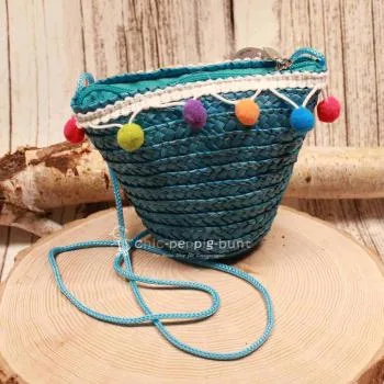 Kleine runde Korbtasche für Kinder aus natürlichem Rattan mit langer Kordel-Schulterband.
