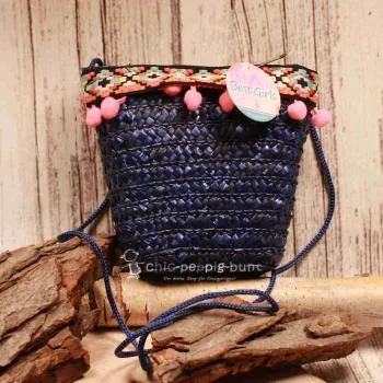Blaue runde Korbtasche für Kinder aus Rattan mit pinken Bommeln, Bordüre und Stoff-Innenfutter.