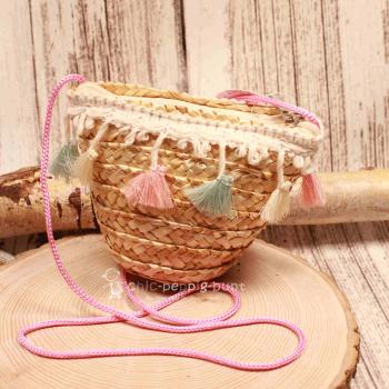 Kleine runde Korbtasche für Kinder aus naturfarbenem Rattan mit bunten Pastell-Quasten und Kordel-Schulterband.