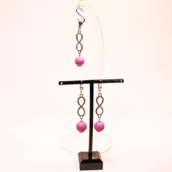 Versilbertes Schmuckset bestehend aus einem Kettenanhänger und passenden Ohrringen mit rosa Korkperlen und funkelndem Strass-Unendlichkeitszeichen.
