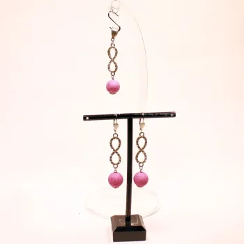 Versilbertes Schmuckset bestehend aus einem Kettenanhänger und passenden Ohrringen mit rosa Korkperlen und funkelndem Strass-Unendlichkeitszeichen.