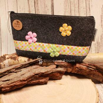 Handgenähte weidräwöl Kosmetiktasche aus grauem Filz mit bunten Punkten und Blumen.