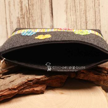 Nahaufnahme der Blumen-Stickerei und der bunt gestreiften Bordüre auf der Handmade Kulturtasche.