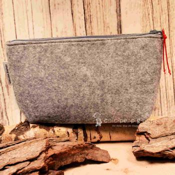 Stabiler Reißverschluss der handgenähten hellgrauen Utensilientasche aus Filz.