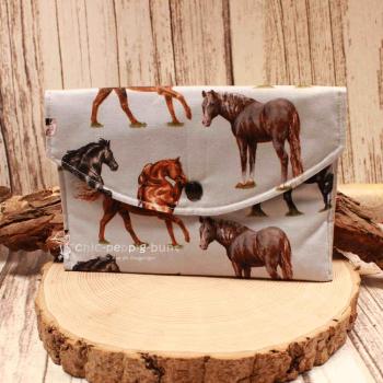 Großer handgenähter Geldbeutel von chic-peppig-bunt aus hellblauem Stoff mit Pferden und grau gepunktetem Innenfutter auf hellem Hintergrund.