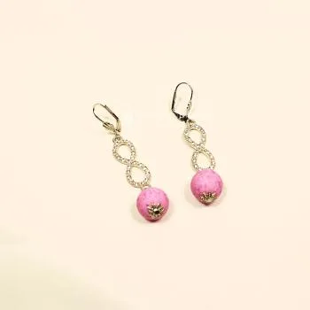 Versilberte Ohrhänger mit Klappbrisur, einer rosa Korkperle und einem funkelnden, strassbesetzten Unendlichkeitszeichen.