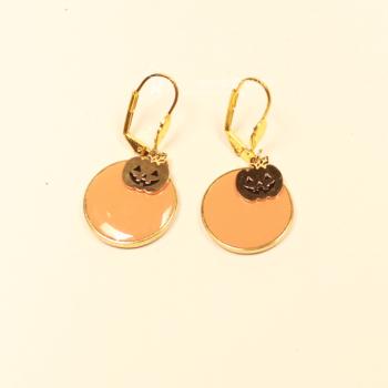 Vergoldete Ohrringe mit großem orangefarbenem Kürbis und kleinem goldenem Gesicht als Hänger für Halloween.