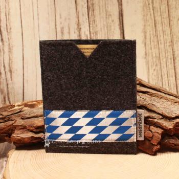 Handgenähte dunkelgraue Filz Passhülle der Marke Weidräwöl mit blau-weißer Bordüre im Bayern-Design für Reisepass und Impfpass.