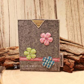 Handgenähte hellgraue Filz Passhülle der Marke Weidräwöl mit drei karierten Blumen-Applikationen und rot-weißer Karobordüre für Ausweise.