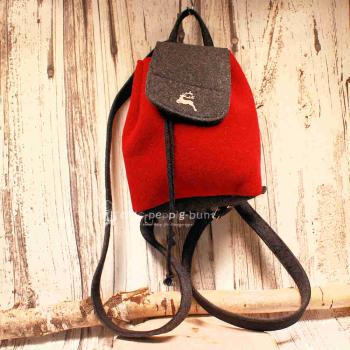 Kleiner rot-schwarzer Filz-Rucksack mit gesticktem Hirschmotiv, Zugband-Verschluss und verstellbaren Schulterriemen vor hellem Hintergrund.