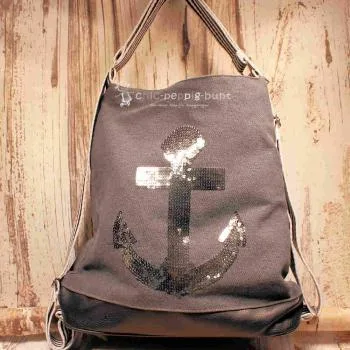 Grauer Rucksack aus Stoff mit silbernem Anker aus Pailletten, braunem Lederboden und gestreiften Gurten, 3-in-1 Funktion als Handtasche.