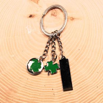Versilberter Kleeblatt Schlüsselanhänger mit Gliederkette und drei Anhängern aus Metall.