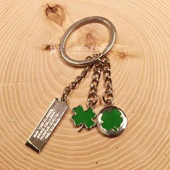 Detailaufnahme der Gravur "May the clover bring you love" auf dem Metall-Taschenanhänger.