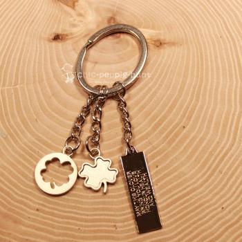 Detailaufnahme der Gravur "May the clover bring you love" auf dem Metall-Taschenanhänger.