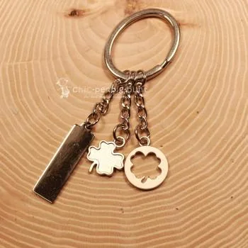 Versilberter Kleeblatt Schlüsselanhänger mit Gliederkette und drei Anhängern aus Metall.