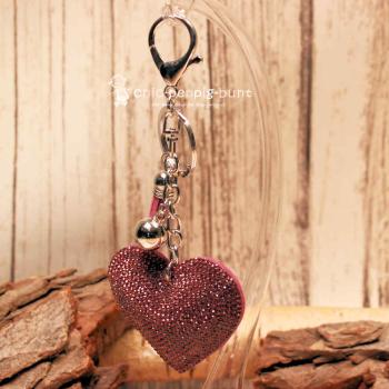 Detailaufnahme der Glitzerseite des Herz-Taschenanhängers mit Metallperle und Schlüsselring.